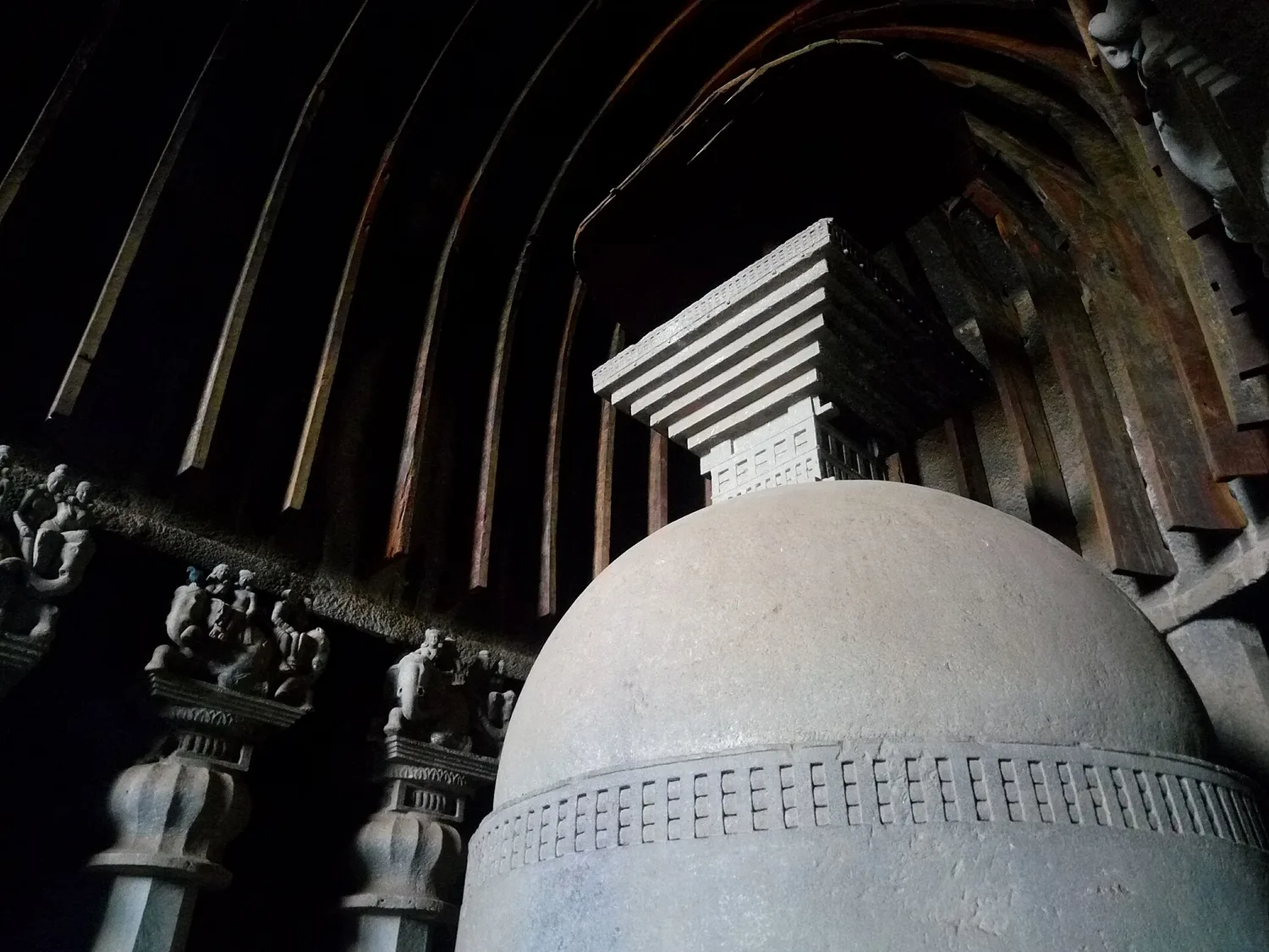 A close view of the stupa and carved column capitals inside Karla Caves.