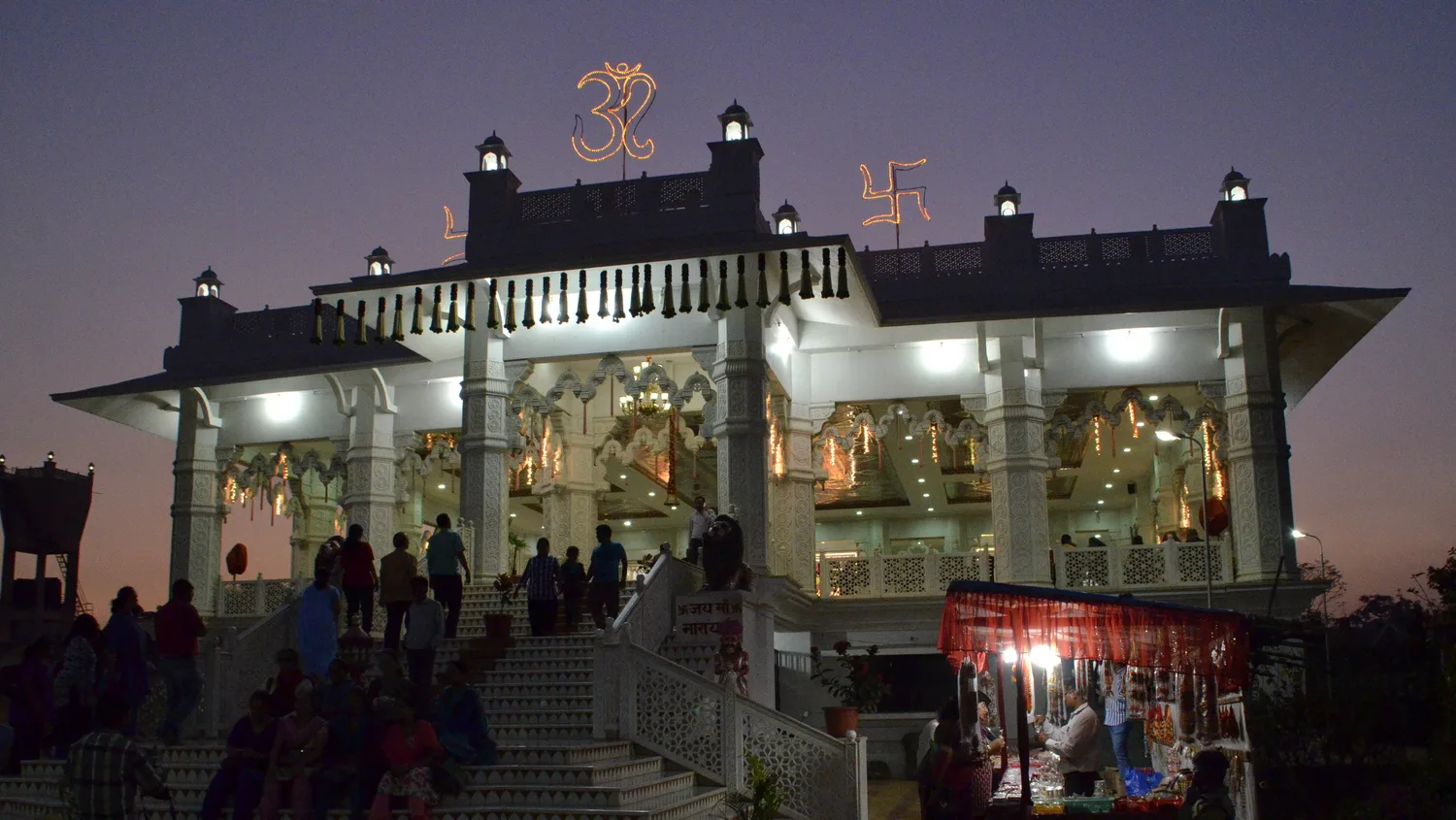 Shree Narayani Dham in Lonavala illuminated at dusk.